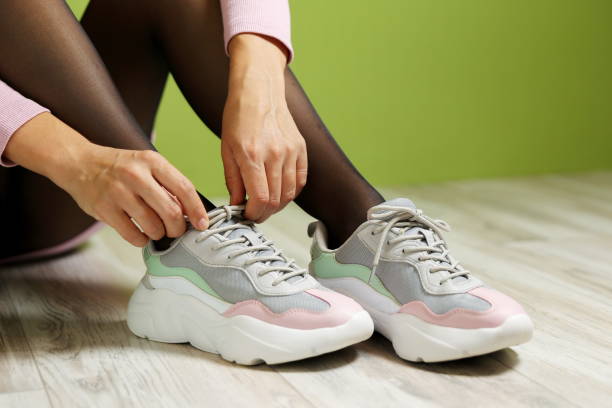 istock woman's legs wearing sport sneakers 1369304596