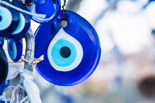 Lot of traditional Turkish amulet Evil Eye or blue eye (Nazar boncugu). Souvenir of Turkey and traditional turkish amulet. Close up, selected focus, shallow depth. Travel souvenir or gift concept