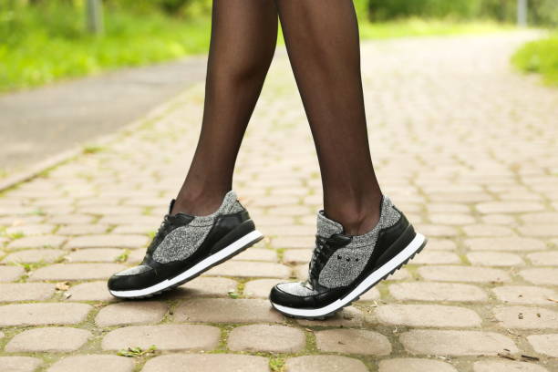 istock woman's legs wearing sport sneakers 1369304717