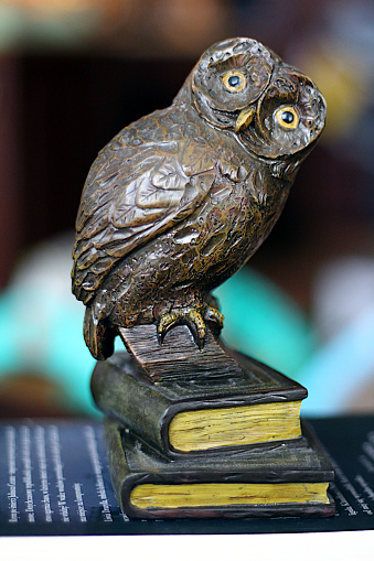 Owl shaped paperweight standing on two book