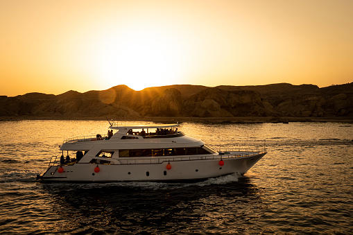 Tourists ride on a two-story yacht on the red sea against the backdrop of a bright sunset. Sharm el Sheikh Egypt. October 15, 2021