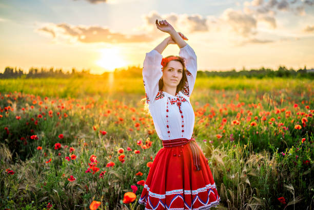 junge frau in nationaler ukrainischer tracht stickhemd tanzt im feld der roten mohnblumen - aboriginal art aborigine rock stock-fotos und bilder
