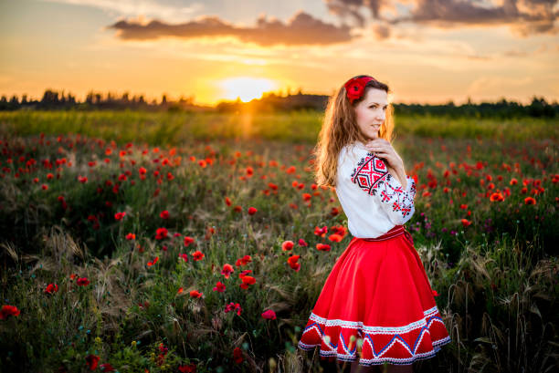 junge frau in nationaler ukrainischer tracht stickhemd tanzt im feld der roten mohnblumen - aboriginal art aborigine rock stock-fotos und bilder