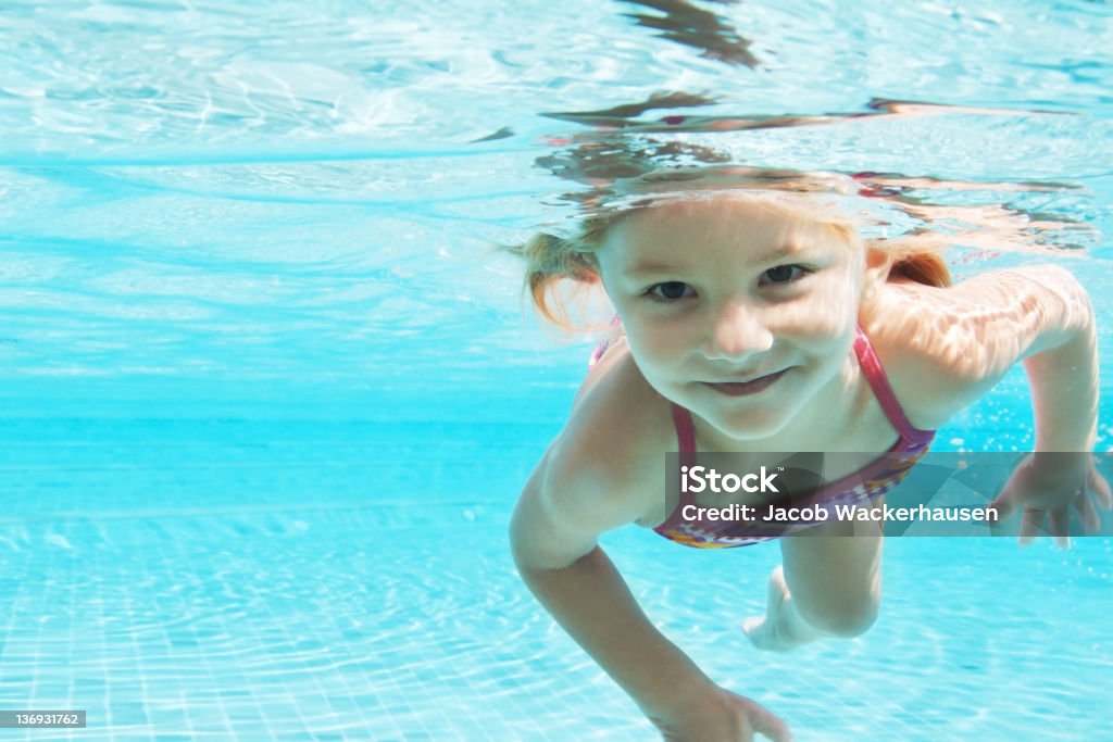 Escaping the summer sun Portrait of a pretty young girl enjoying a swim on a hot day looking at you Swimming Stock Photo