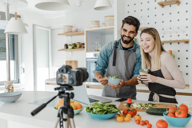 jovem casal vlogging na cozinha - women home video camera camera vitality - fotografias e filmes do acervo