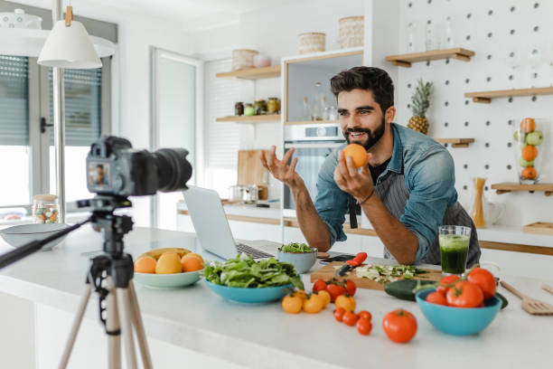 istock Young handsome man vlogging in the kitchen 1369318158