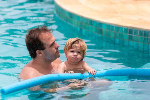 istock father playing with his son in the pool, narrow focus 1369320069