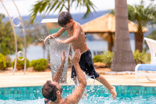 istock father playing with his son in the pool, narrow focus 1369320091