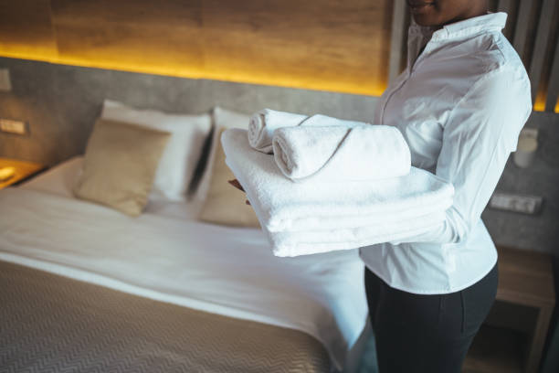 istock Young hotel maid making the bed with clean fresh towels. 1369323262