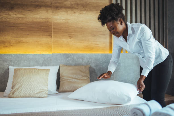 istock Maid working at a hotel making the bed and pillows. 1369323399