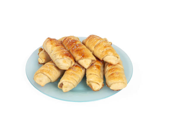 Croissants with sesame seeds on a blue plate are baked by yourself. Baking isolate on a white background.