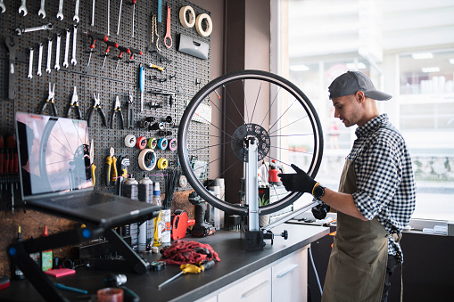 Mechanic in workshop repairing a bicycle tyre