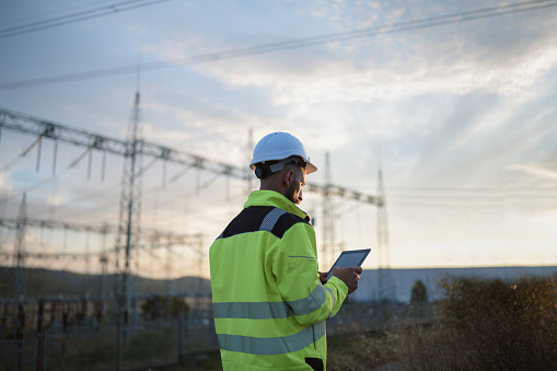 Side view of one industry engineer working at electricity control panel.