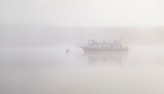 Foggy lake and fishing boat