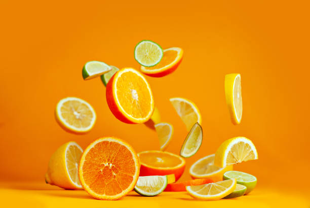 istock Oranges, lemons and limes cut into slices. Citrus vegetables fly on an orange background. Preparing vegetables for juice and cocktails. 1369328162
