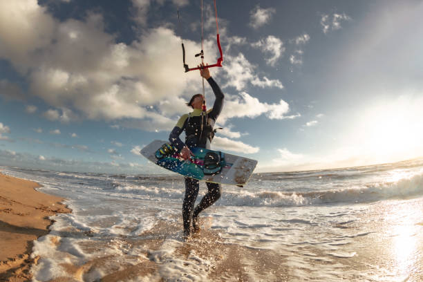 istock Kite surfer stands in water with wakeboard 1369328269