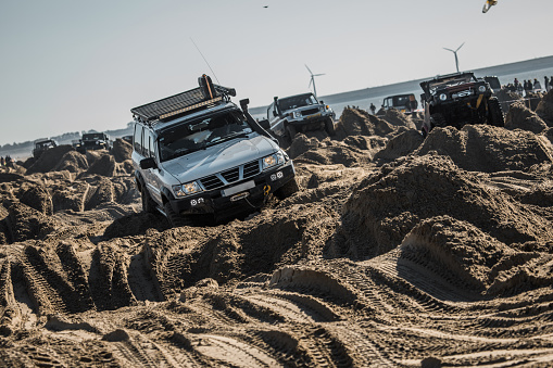 Offroad truck and other vehicles on a sandy beach