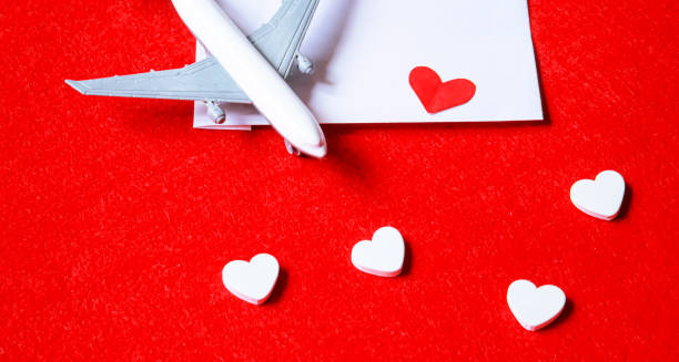 istock Hearts and a plane on a red background. Valentine's Day. Selective focus. 1369329899
