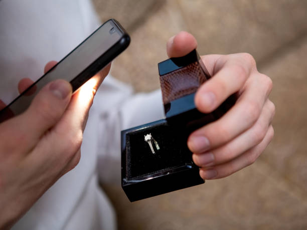 istock A young man holds in his hands a jewelry box with a diamond ring inside 1369331254