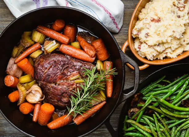 Pot roast in a cast iron dutch oven, green beans and mushed potato.