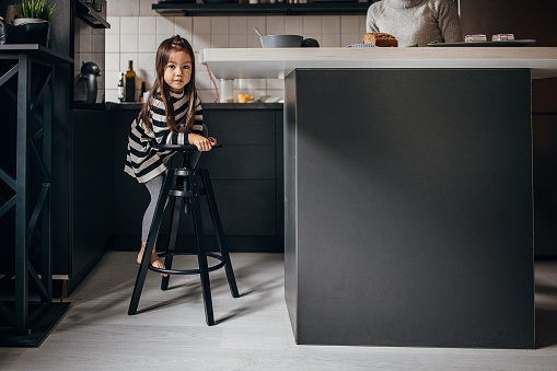 One girl, cute little girl in kitchen at home.