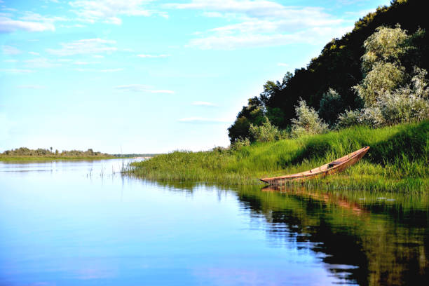 old boat riverside green grass, green trees, blue sky - loch rowboat lake landscape imagens e fotografias de stock