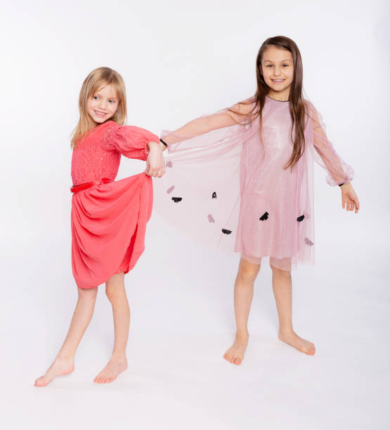 장난 꾸러기 아이, 재미있는 개념. 핑크 드레스를 입고 흰색 배경에 고립 된 춤 6-8 세의 귀여운 두 여자의 초상화. 어머니의 날, 사랑의 가족, 부모 어린 시절 개념 - female 8 9 years child excitement 뉴스 사진 이미지