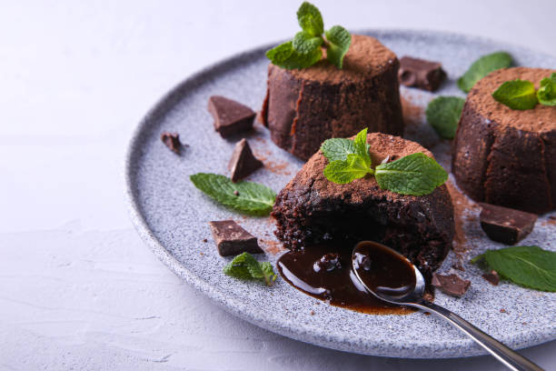 istock Composition with chocolate fondants on a gray background. Decorated with mint. 1369337560