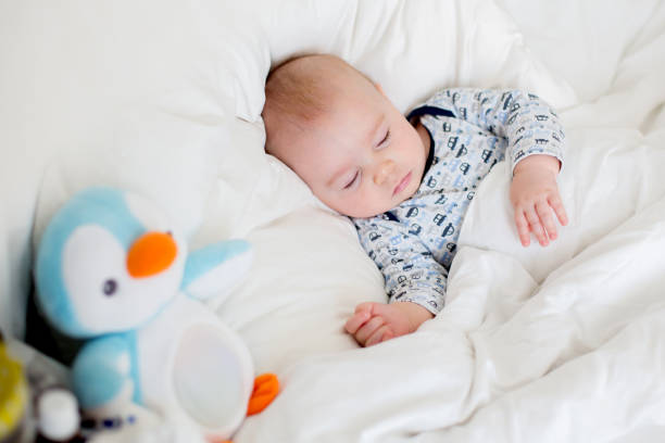 istock Sick child boy lying in bed with a fever, resting at home 1369338285