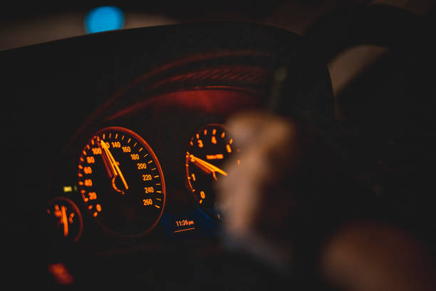 close up car dashboard con donna asiatica che tiene lo sterzo alla guida di notte - car steering wheel windshield speedometer foto e immagini stock