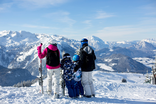 Portrait of smiling family sitting on ski lift, Kals am Grossglockner, Austria.
