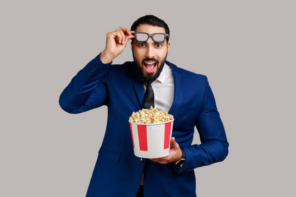 映画映画に感銘を受け、ポップコーンを持ち、素晴らしい映画を見て、3dメガネを上げています。 - boxing caucasian men business ストックフォトと画像