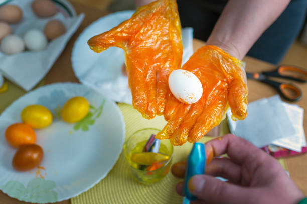 Easter egg painting.woman coloring easter eggs in the kitchen at home.