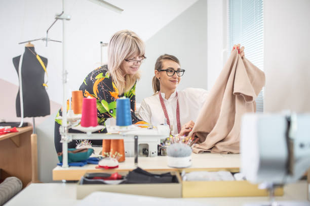 positive working environment as two female tailors check the quality of their work in a small workshop. - mannequin dressmakers model tape measure female imagens e fotografias de stock