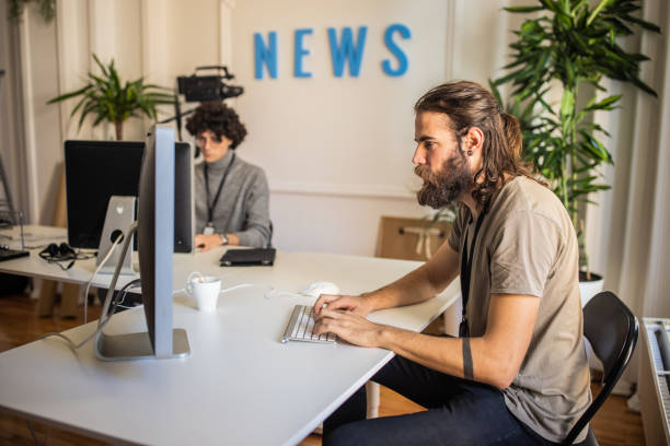 istock Young male journalists, working on computer at the editorial office 1369342540