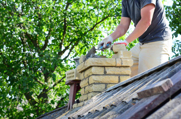 reparación y reconstrucción de una chimenea de ladrillo. un contratista de construcción está volviendo a comprar una chimenea en una casa con techo de asbesto. - chimney sweeping fotografías e imágenes de stock