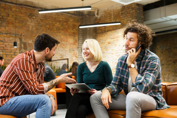 istock Three young employees are sitting and talking. Start-up. 1369343761