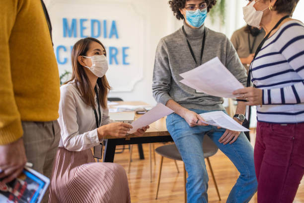 istock Responsible journalists wear protective face mask at the editorial office 1369343916