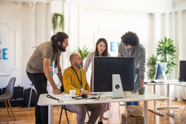 istock Multiracial coworkers working on a new publication on computer 1369344446