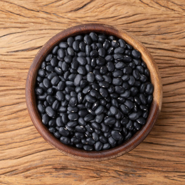 istock Raw black beans in a bowl over wooden table 1369346193