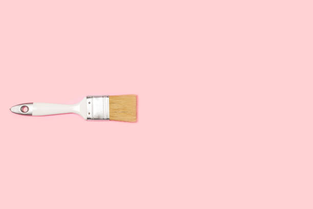 istock A wooden white paintbrush on a pink background 1369347448