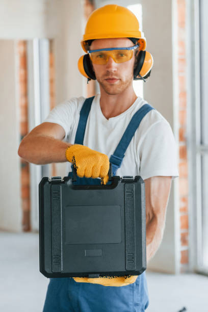 istock Modern repair. Young man working in uniform at construction at daytime 1369350113