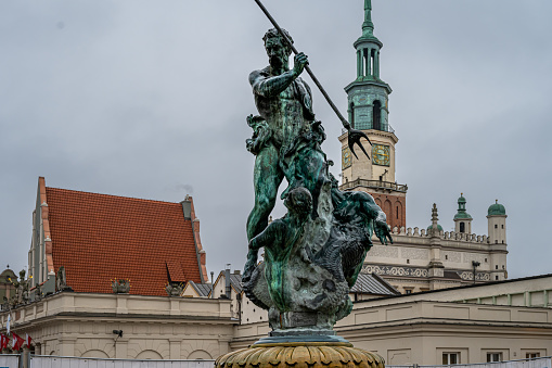 The Neptune Fountain on the Main Market (Rynek) square in the Old Town of Poznan, Poland. The city hall tower in the background