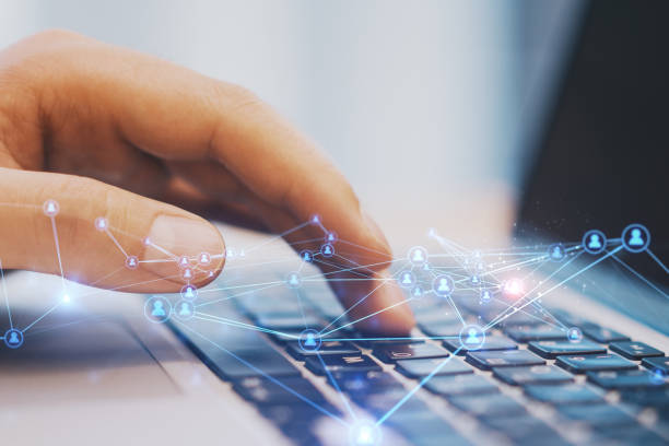 istock Close up of hand at desktop using laptop with abstract glowing polygonal network with people icons. Blurry background. Online networking, multimedia, digital communication concept. Double exposure. 1369351727