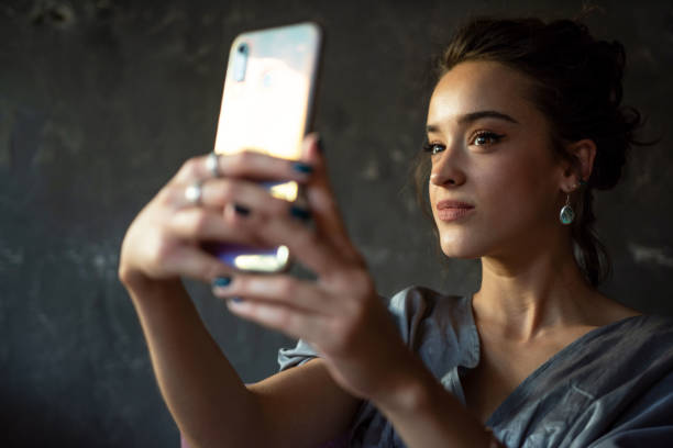 istock Beautiful young woman taking a selfie 1369351988