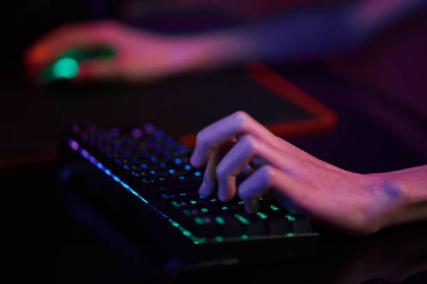 istock Gamer play computer game, use rgb neon colored keyboard 1369353149