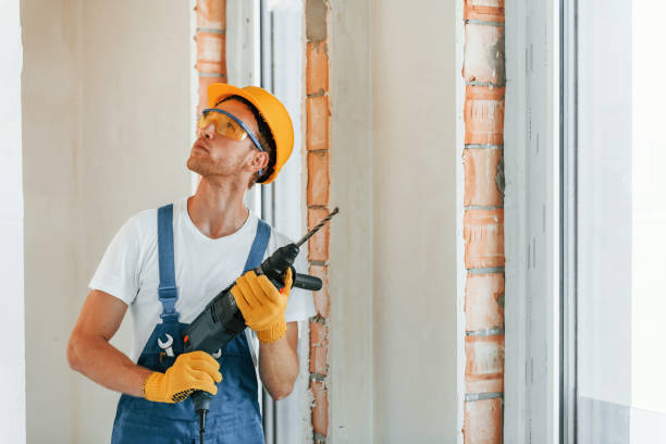 istock Holding drill. Young man working in uniform at construction at daytime 1369353296