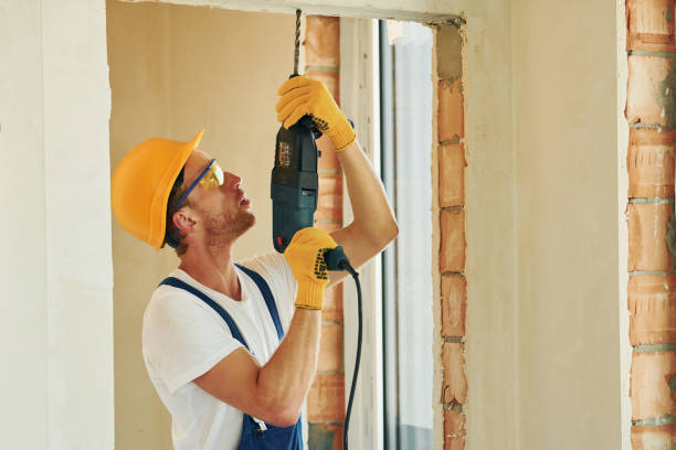 istock Holding drill. Young man working in uniform at construction at daytime 1369353298