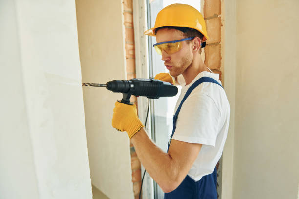 istock Holding drill. Young man working in uniform at construction at daytime 1369353322