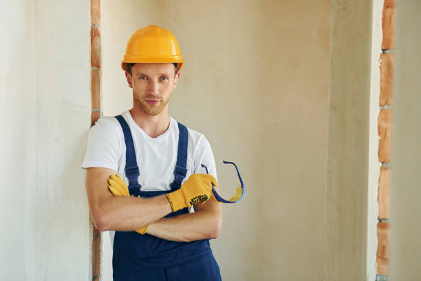 istock Professional service. Young man working in uniform at construction at daytime 1369353325